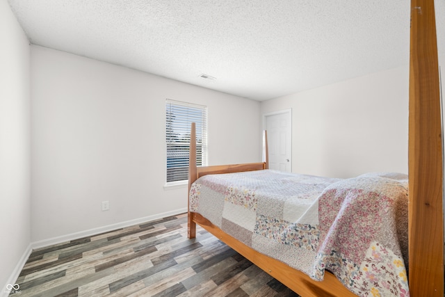 bedroom with hardwood / wood-style flooring and a textured ceiling