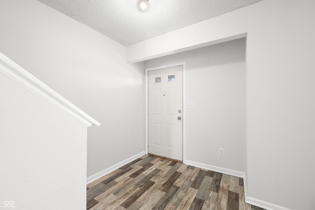 foyer featuring dark hardwood / wood-style floors and a textured ceiling