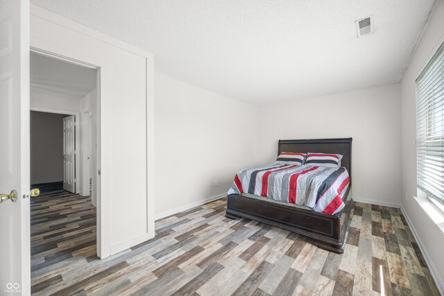 bedroom featuring hardwood / wood-style floors and a textured ceiling