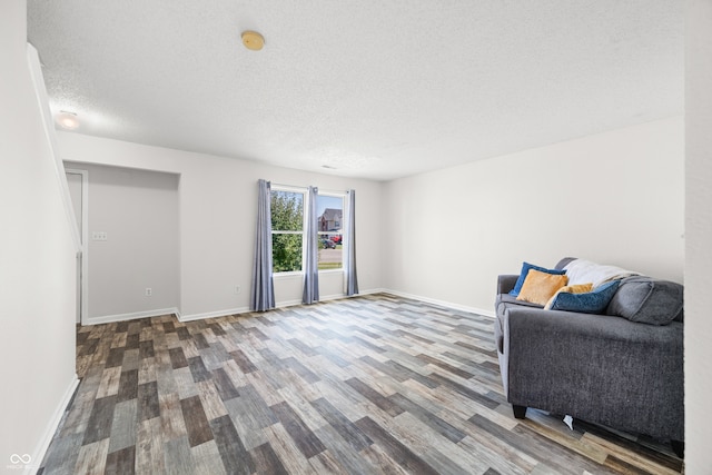 living area featuring wood-type flooring and a textured ceiling