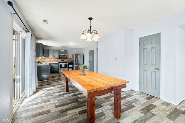 dining area featuring hardwood / wood-style floors, an inviting chandelier, and a healthy amount of sunlight