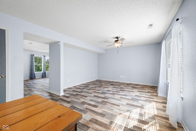 empty room featuring hardwood / wood-style flooring, a textured ceiling, and ceiling fan