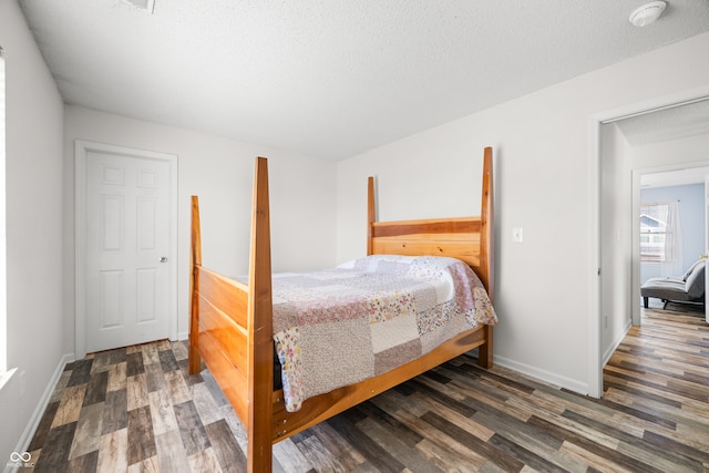 bedroom with dark hardwood / wood-style flooring and a textured ceiling