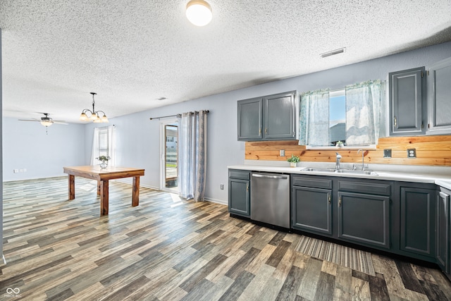 kitchen featuring pendant lighting, sink, a textured ceiling, dark wood-type flooring, and dishwasher