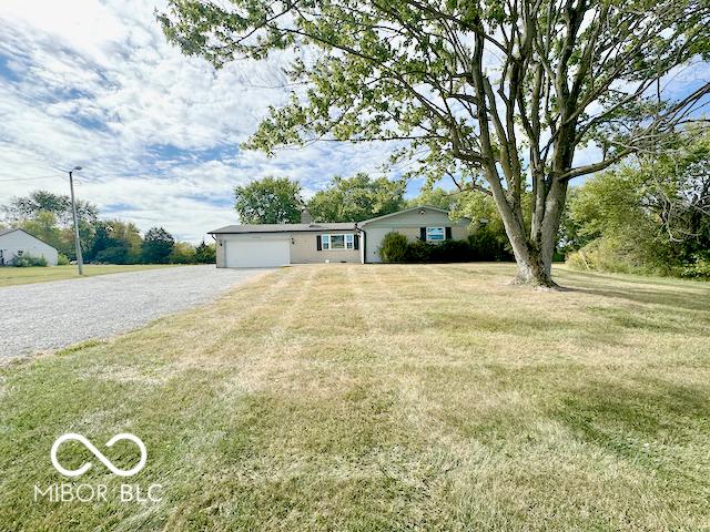 ranch-style home featuring a front lawn and a garage