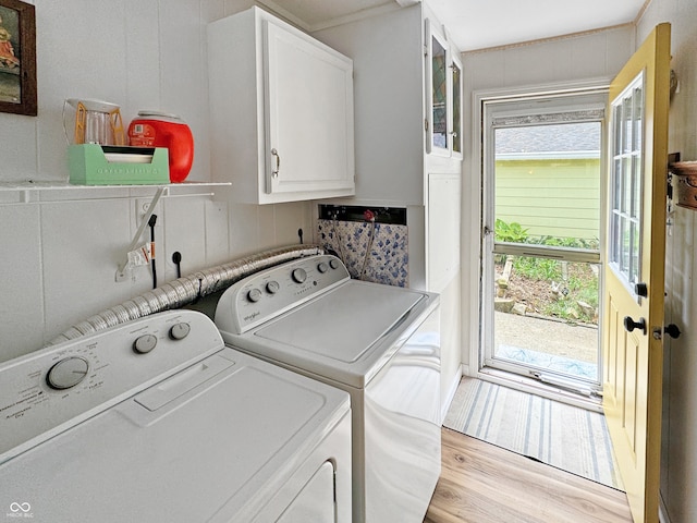 washroom with plenty of natural light, cabinets, light wood-type flooring, and washing machine and clothes dryer