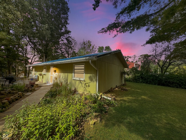 property exterior at dusk with a yard