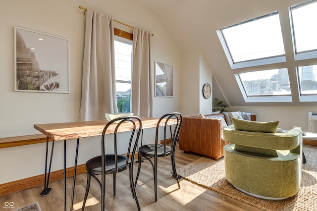 interior space featuring light hardwood / wood-style floors and lofted ceiling with skylight