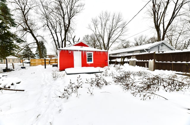 snowy yard featuring an outbuilding