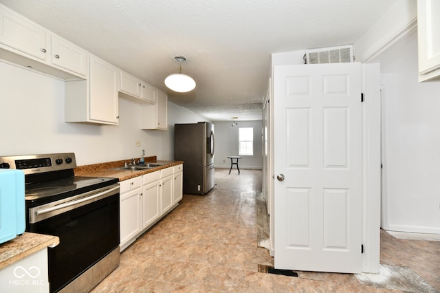 kitchen featuring white cabinets, pendant lighting, a textured ceiling, and appliances with stainless steel finishes