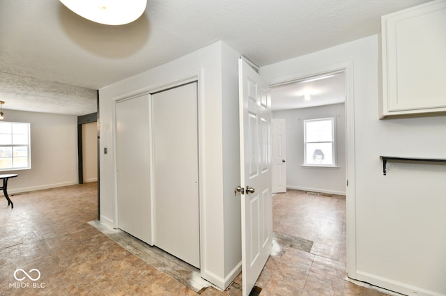 hallway with a textured ceiling