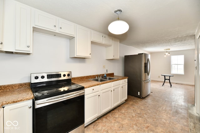 kitchen with appliances with stainless steel finishes, a textured ceiling, sink, white cabinetry, and hanging light fixtures