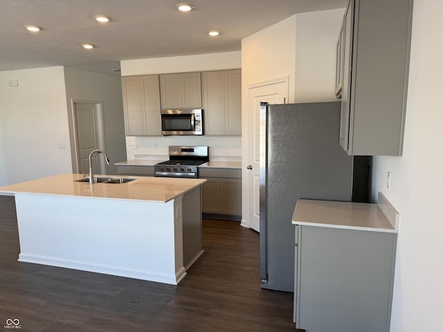 kitchen with appliances with stainless steel finishes, dark hardwood / wood-style flooring, gray cabinets, and sink