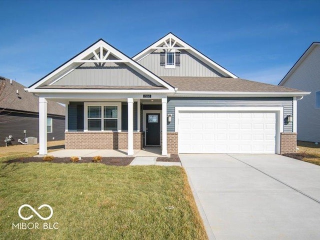 craftsman inspired home featuring a garage, a front lawn, and covered porch