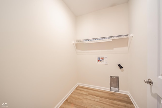 clothes washing area with hookup for a washing machine and light hardwood / wood-style flooring