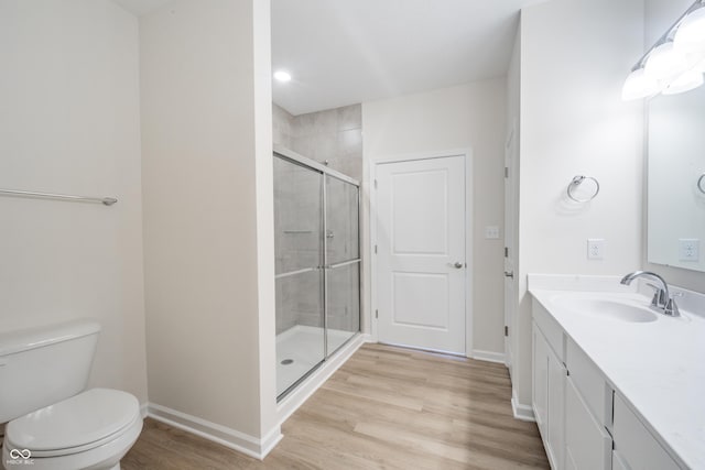 bathroom featuring hardwood / wood-style floors, vanity, toilet, and an enclosed shower