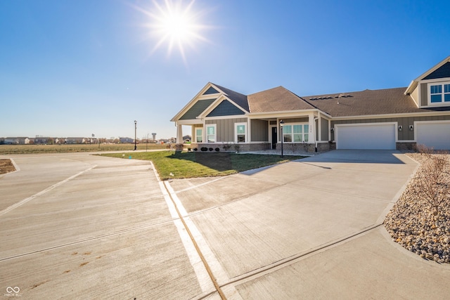 view of front of home featuring a front yard, a porch, and a garage