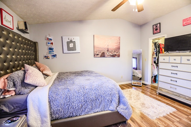 bedroom featuring a spacious closet, a closet, lofted ceiling, ceiling fan, and hardwood / wood-style floors