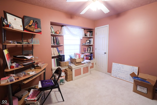 carpeted office with a textured ceiling and ceiling fan