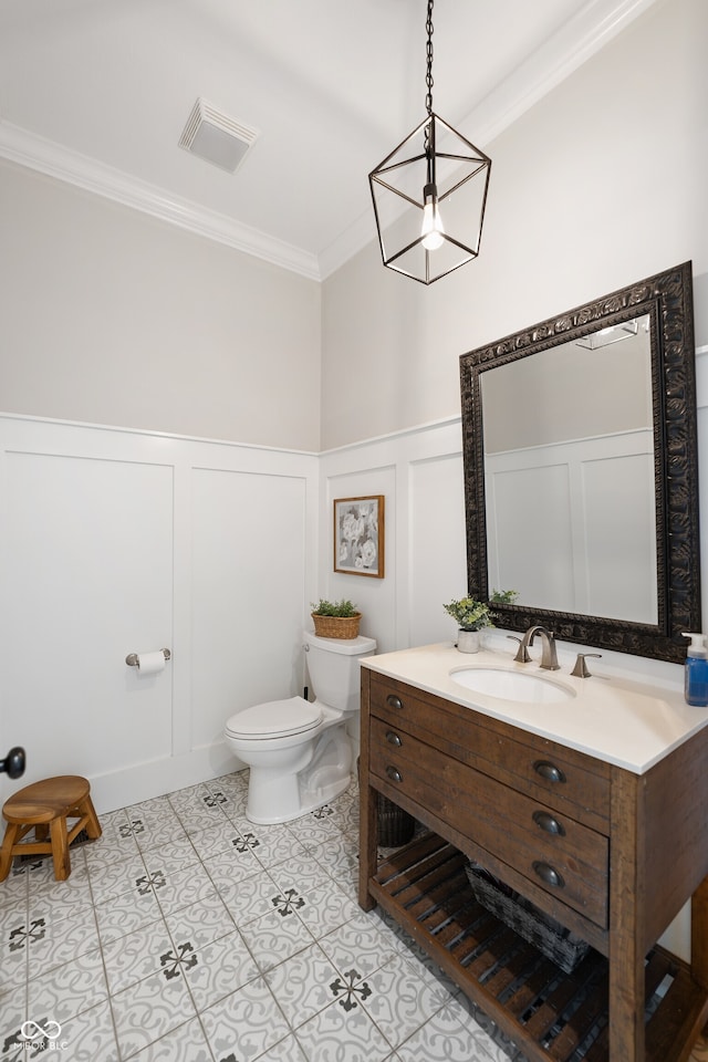 bathroom with ornamental molding, vanity, toilet, and tile patterned floors