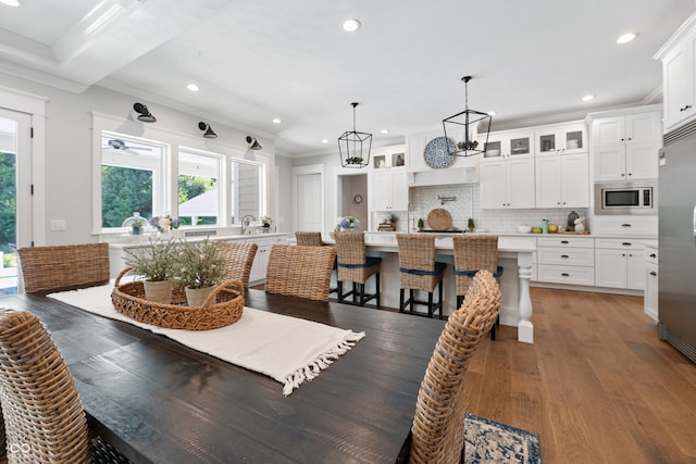 dining area with ornamental molding and dark hardwood / wood-style flooring