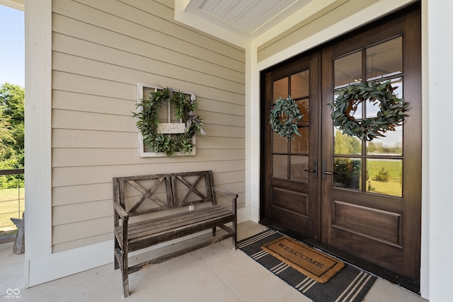 view of exterior entry featuring french doors and covered porch