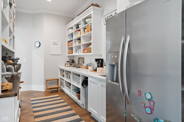 kitchen with stainless steel refrigerator with ice dispenser, dark hardwood / wood-style floors, ornamental molding, and white cabinetry