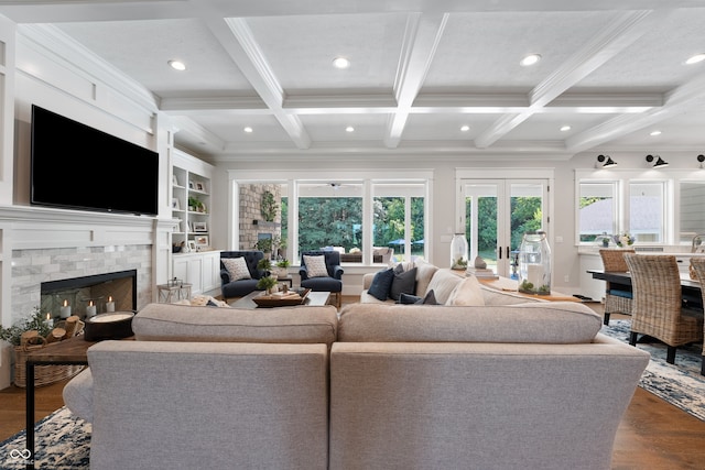 living room featuring ornamental molding, beam ceiling, wood-type flooring, coffered ceiling, and a fireplace