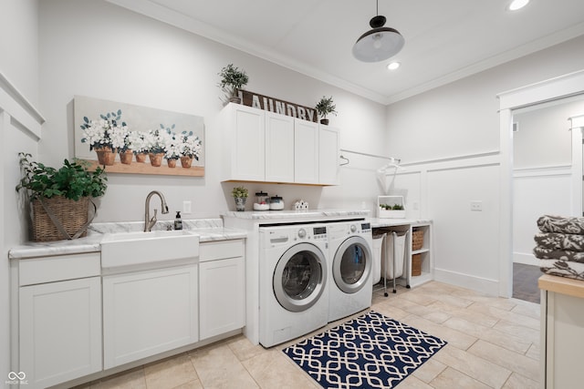 clothes washing area with light tile patterned floors, sink, cabinets, crown molding, and washer and dryer