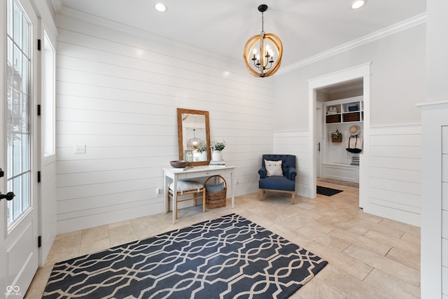 living area with crown molding, wooden walls, and a chandelier