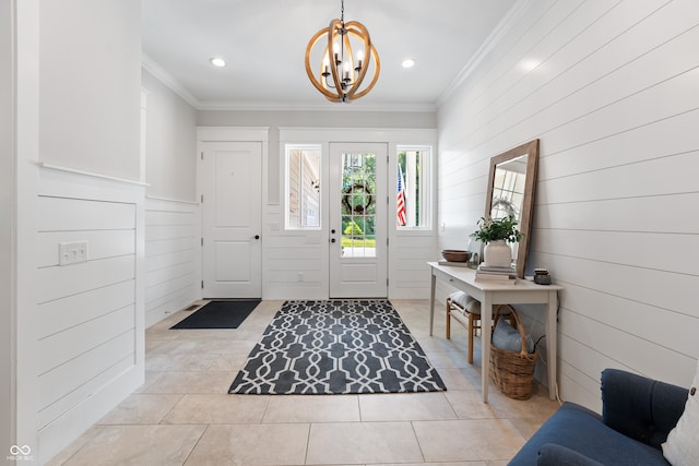 tiled foyer entrance featuring crown molding, wooden walls, and a notable chandelier