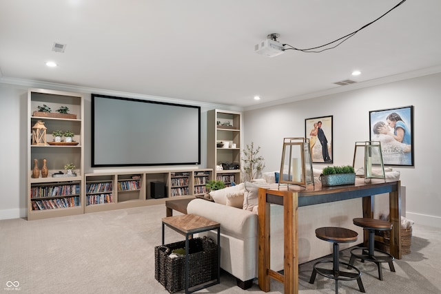 carpeted cinema room with built in shelves and crown molding