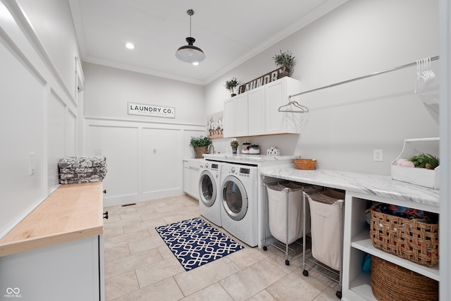 washroom featuring cabinets, crown molding, light tile patterned flooring, and washing machine and dryer