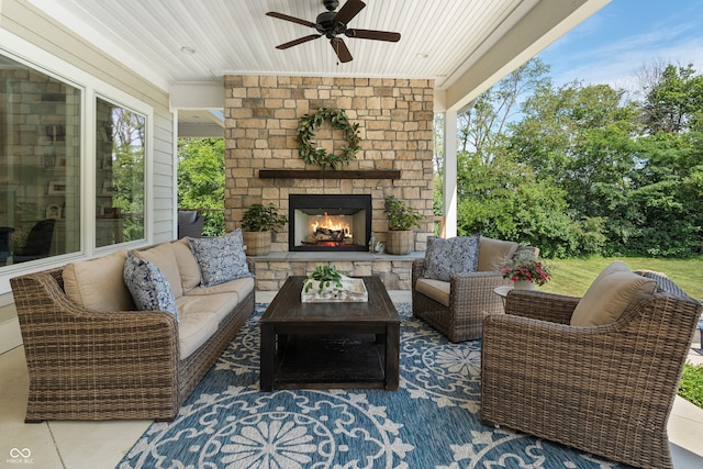 view of patio / terrace with ceiling fan and an outdoor living space with a fireplace