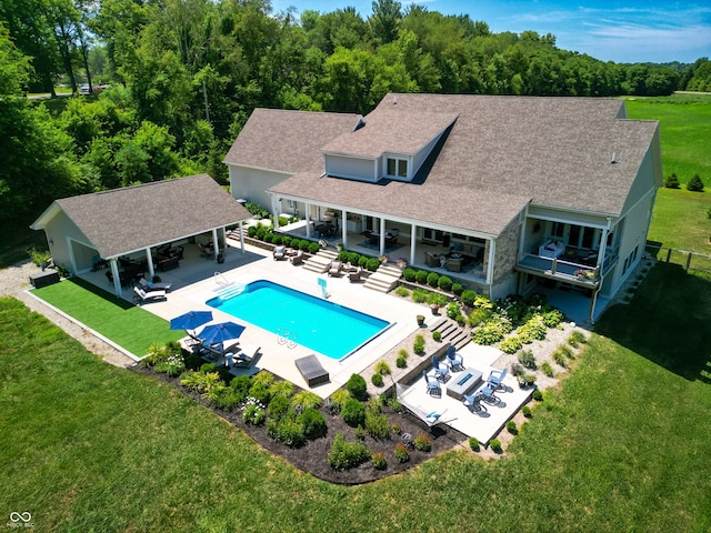 view of pool with an outdoor living space, a patio area, and a yard