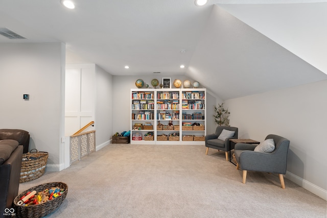 sitting room with vaulted ceiling and light carpet