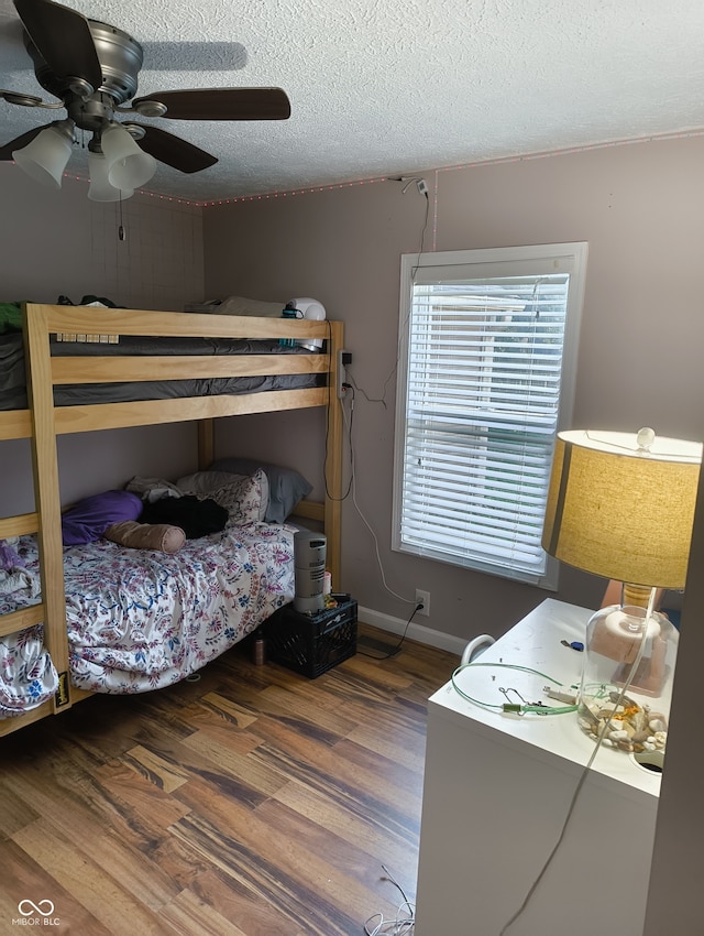 bedroom with ceiling fan, hardwood / wood-style floors, and a textured ceiling