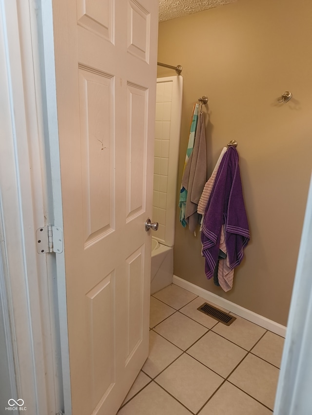 bathroom featuring shower / tub combination, tile patterned flooring, and a textured ceiling