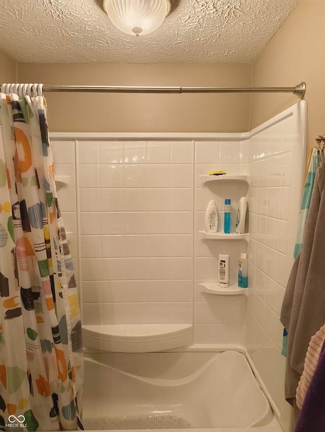 bathroom featuring shower / tub combo with curtain and a textured ceiling