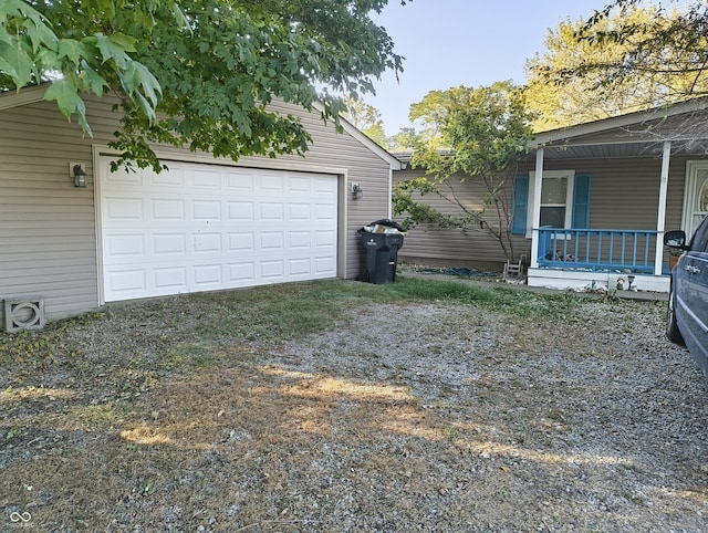 view of side of home with a garage and covered porch