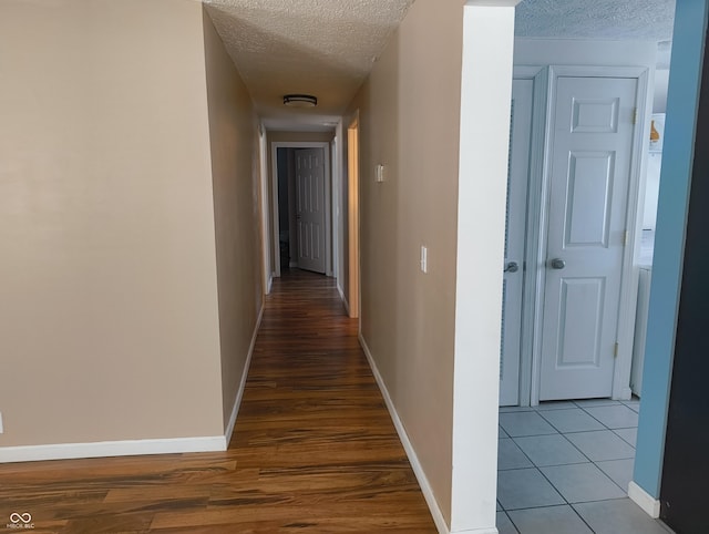 corridor with tile patterned floors and a textured ceiling