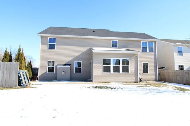 view of snow covered rear of property