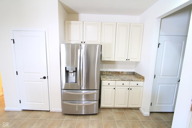 kitchen with light tile patterned floors and stainless steel fridge