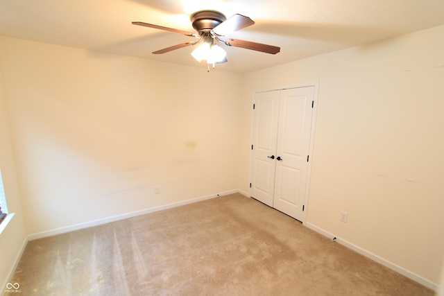 empty room featuring light colored carpet and ceiling fan