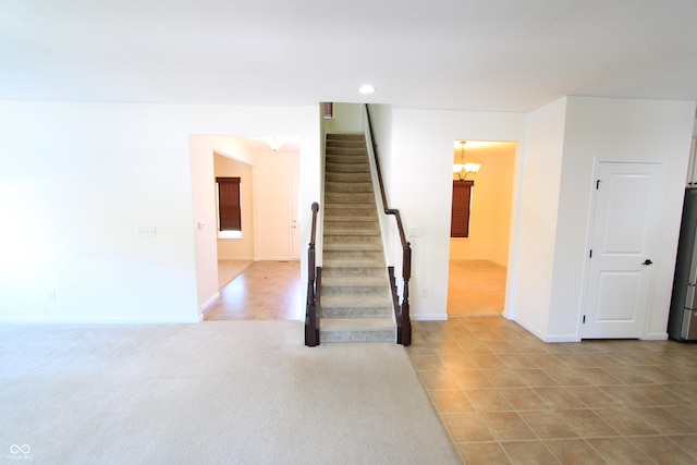 stairway featuring carpet floors and a chandelier