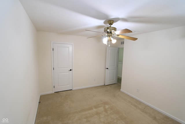 empty room featuring ceiling fan and light carpet