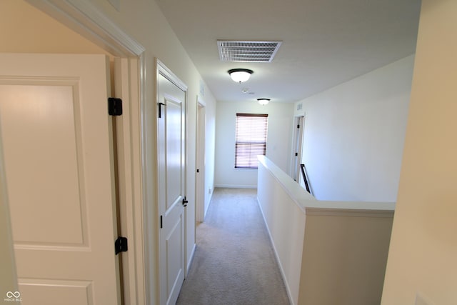 hall with light colored carpet