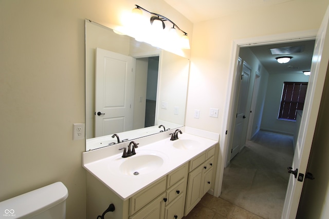 bathroom with tile patterned flooring, vanity, and toilet