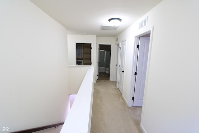 hallway featuring light colored carpet