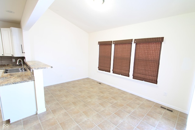 kitchen with sink, white cabinets, and decorative backsplash